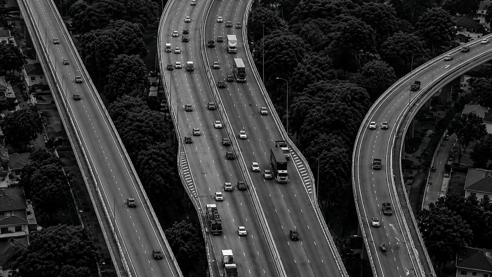 Aerial view of a busy motorway with multiple lanes and slip-roads — establishing the visual metaphor for the spinal motorway.